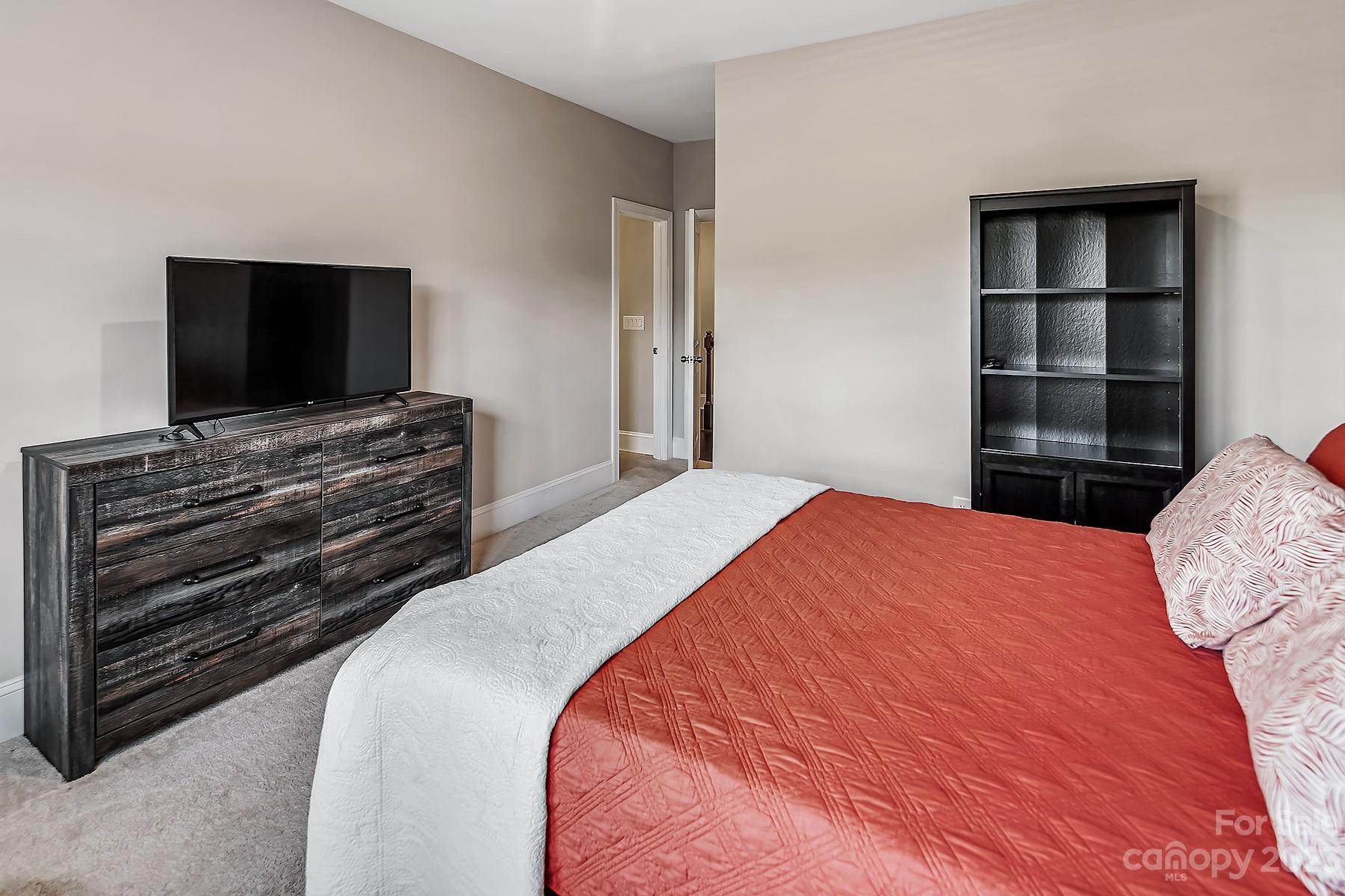 1004 Princessa Drive Wesley Chapel, NC 28104 - Photo 26 of 40 a bedroom with a bed and a flat screen tv