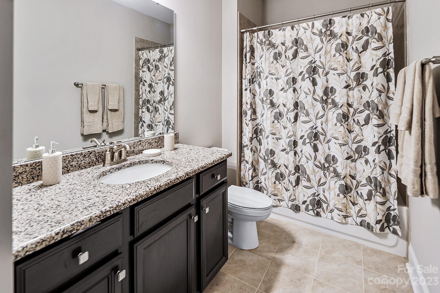 1004 Princessa Drive Wesley Chapel, NC 28104 - Photo 27 of 40 a bathroom with a granite countertop sink toilet and mirror