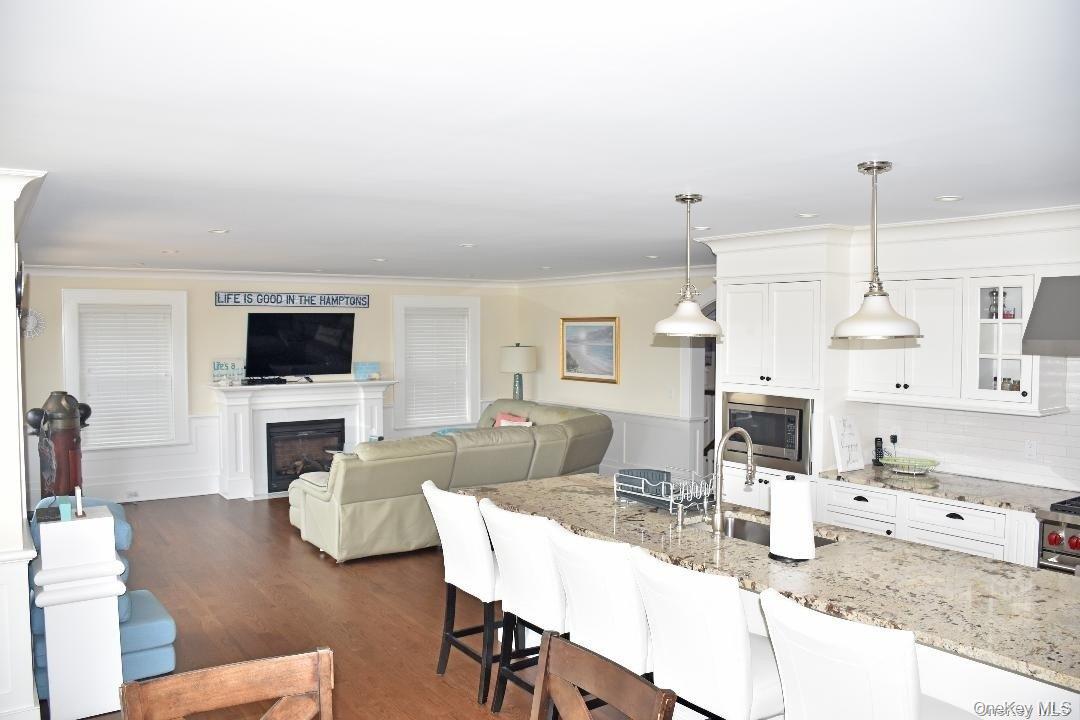 493 Dune Road Westhampton Beach, NY 11978 - Photo 4 of 11 a living room with furniture a flat screen tv and a fireplace