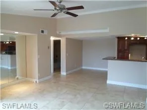 a living room with furniture a flat screen tv and kitchen view