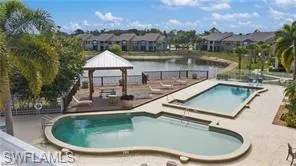 a view of a swimming pool with lawn chairs and plants