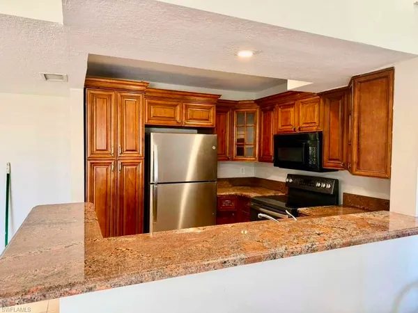 a kitchen with stainless steel appliances granite countertop a stove microwave and sink
