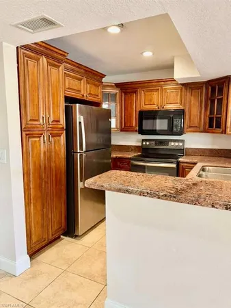 a kitchen with stainless steel appliances granite countertop a refrigerator and a sink