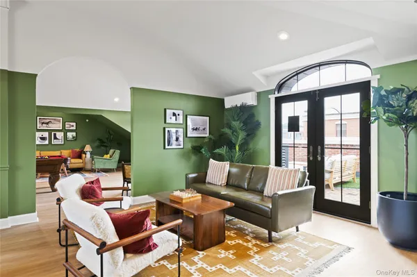 a dining room with furniture a rug and a potted plant
