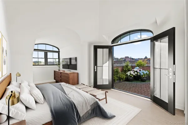 a bedroom with a bed and a large window