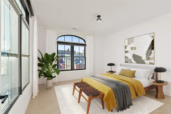 a bedroom with a large bed and a potted plant