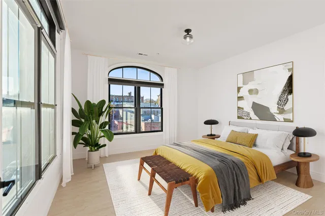 a bedroom with a large bed and a potted plant