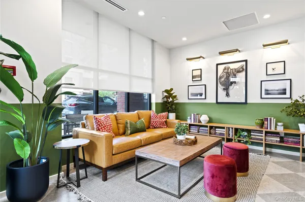a living room with furniture potted plant and a large window