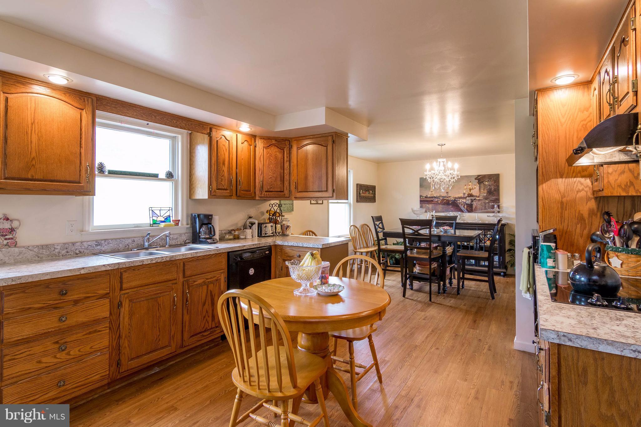 4009 Bill Moxley Road Mount Airy, MD 21771 - Photo 4 of 22 a kitchen with stainless steel appliances wooden floor dining table and chairs