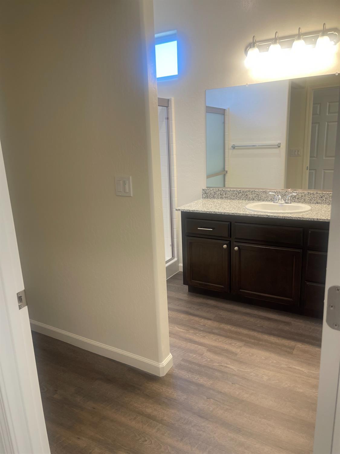 13320 4th Street, Unit LOT1 Parlier, CA 93648 - Photo 7 of 12 a bathroom with a sink and a mirror