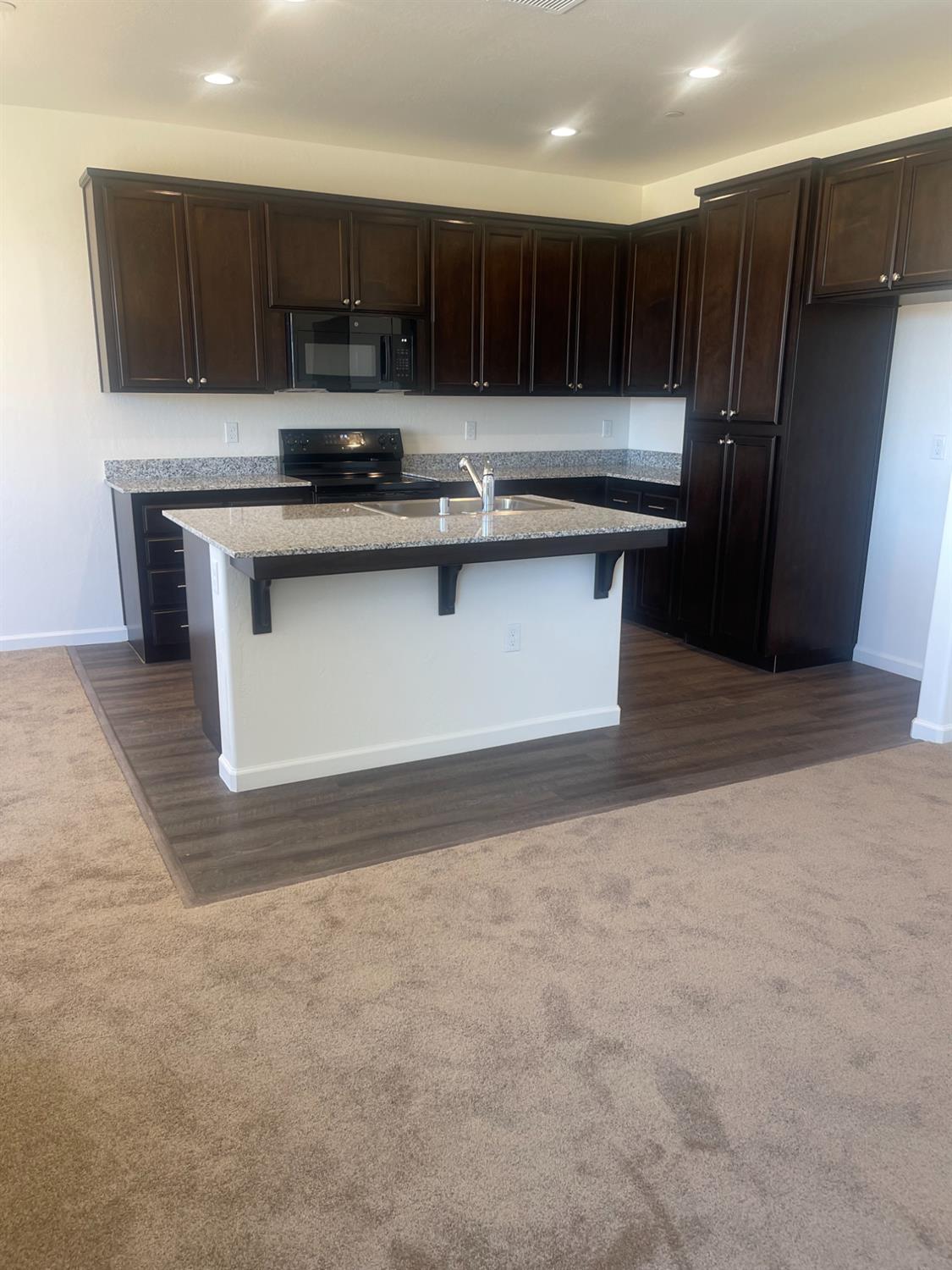 13320 4th Street, Unit LOT1 Parlier, CA 93648 - Photo 9 of 12 a kitchen with kitchen island stainless steel appliances a sink stove and refrigerator