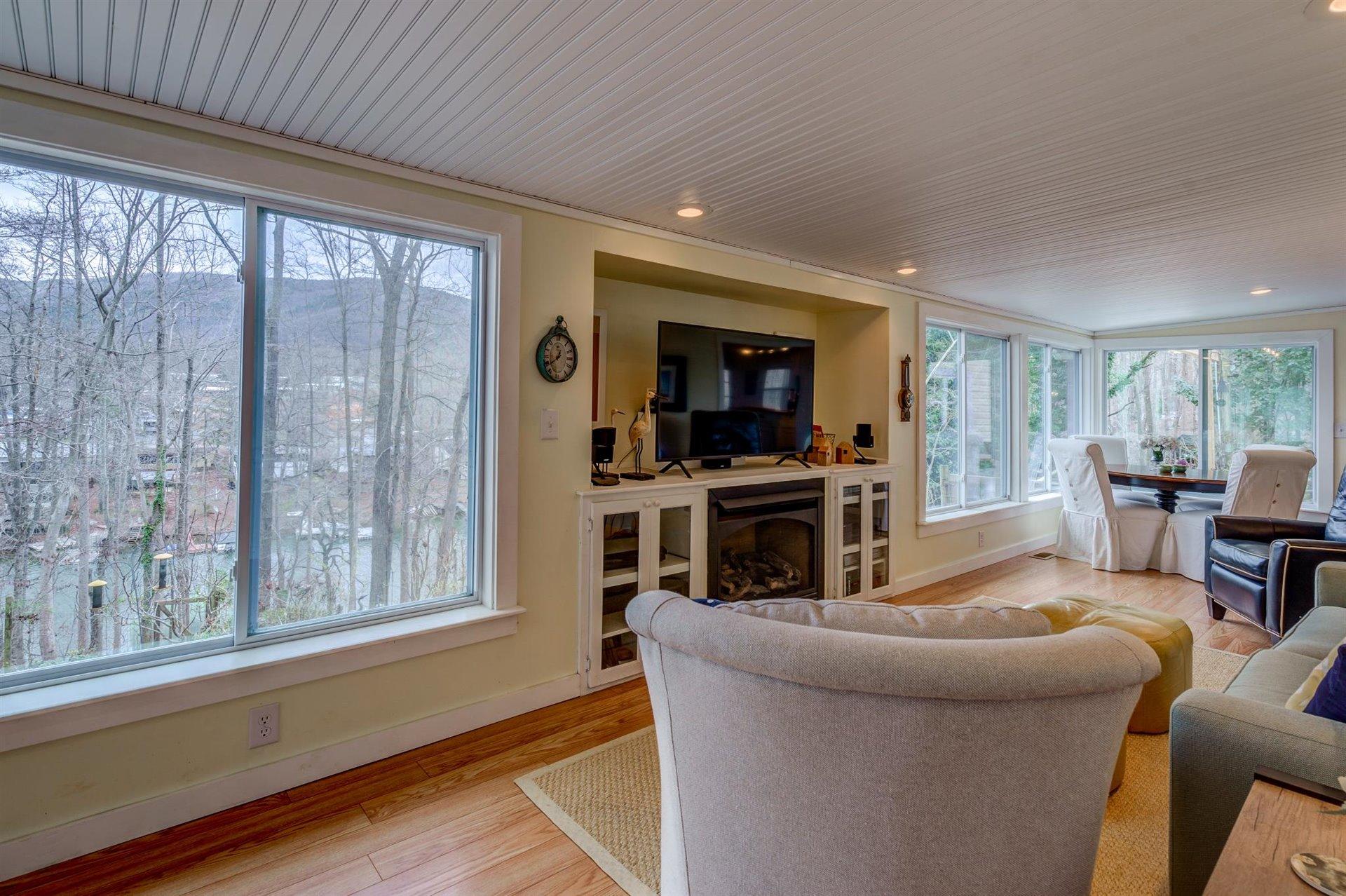 232 Munsons Road Penhook, VA 24137 - Photo 24 of 50 a living room with furniture a fireplace and a flat screen tv