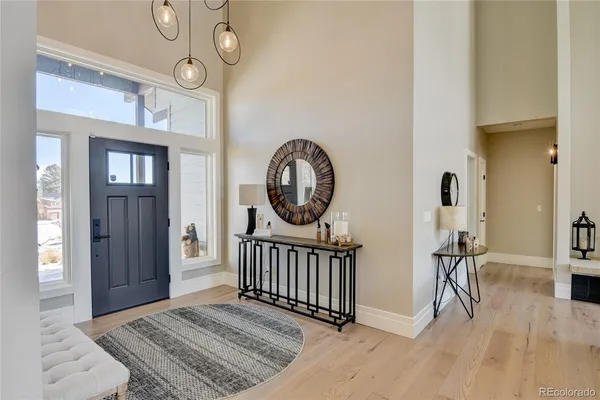 a view of a hallway with entryway wooden floor and front door