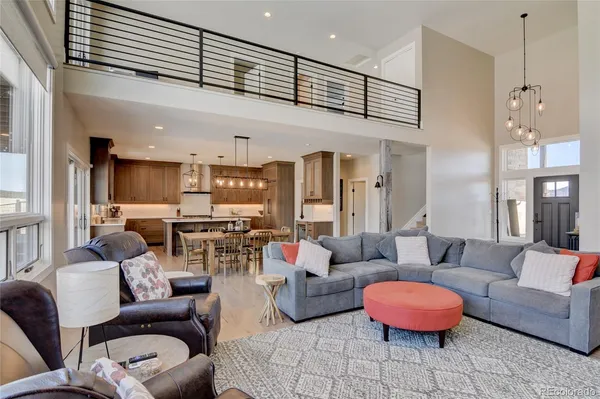 a living room with furniture kitchen view and a chandelier