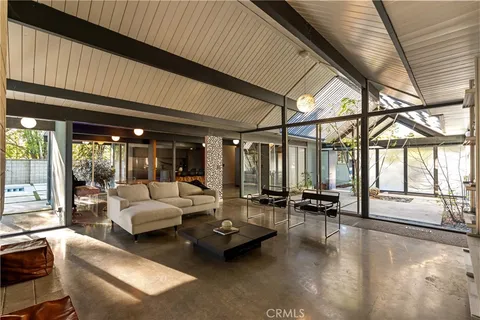 a living room with furniture and floor to ceiling windows