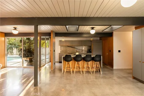 a dining room with furniture and a large window