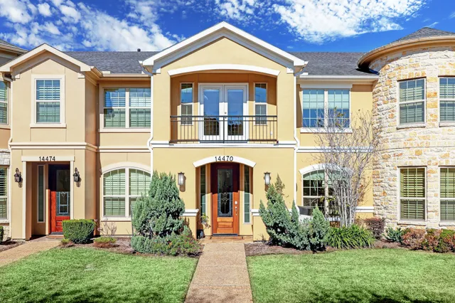 front view of a brick house with a yard