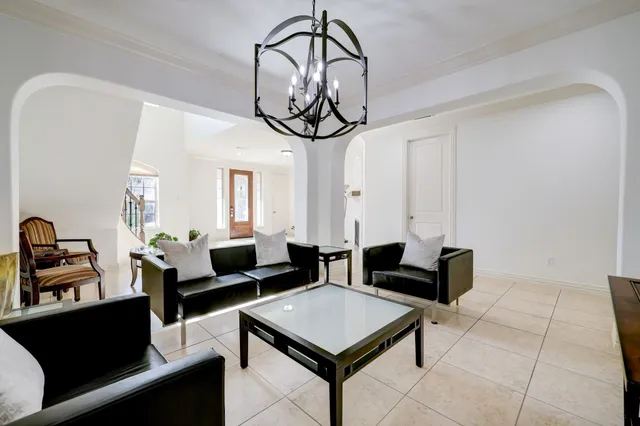 a living room with couches a dining table and kitchen view with wooden floor