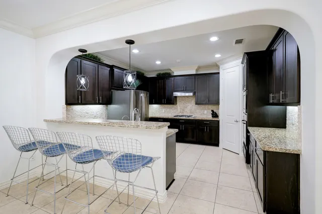 a kitchen with stainless steel appliances granite countertop a refrigerator sink stove and microwave