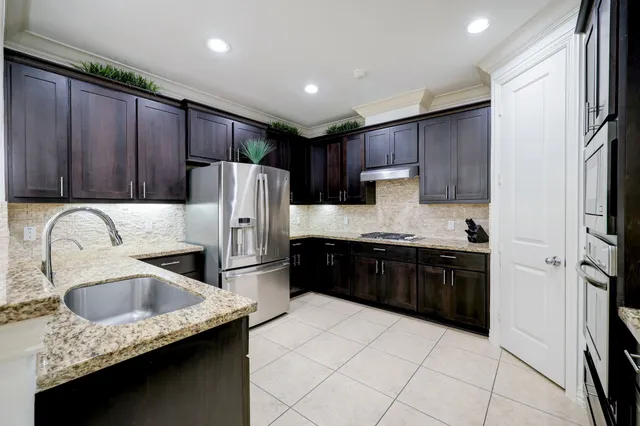 a kitchen with stainless steel appliances granite countertop a refrigerator and a sink