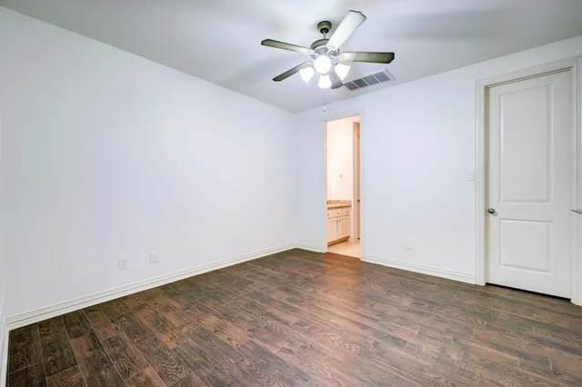 a view of a big room with wooden floor and windows
