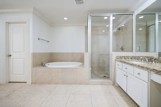 a bathroom with a granite countertop bathtub shower sink and mirror