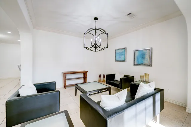 a living room with furniture and a chandelier