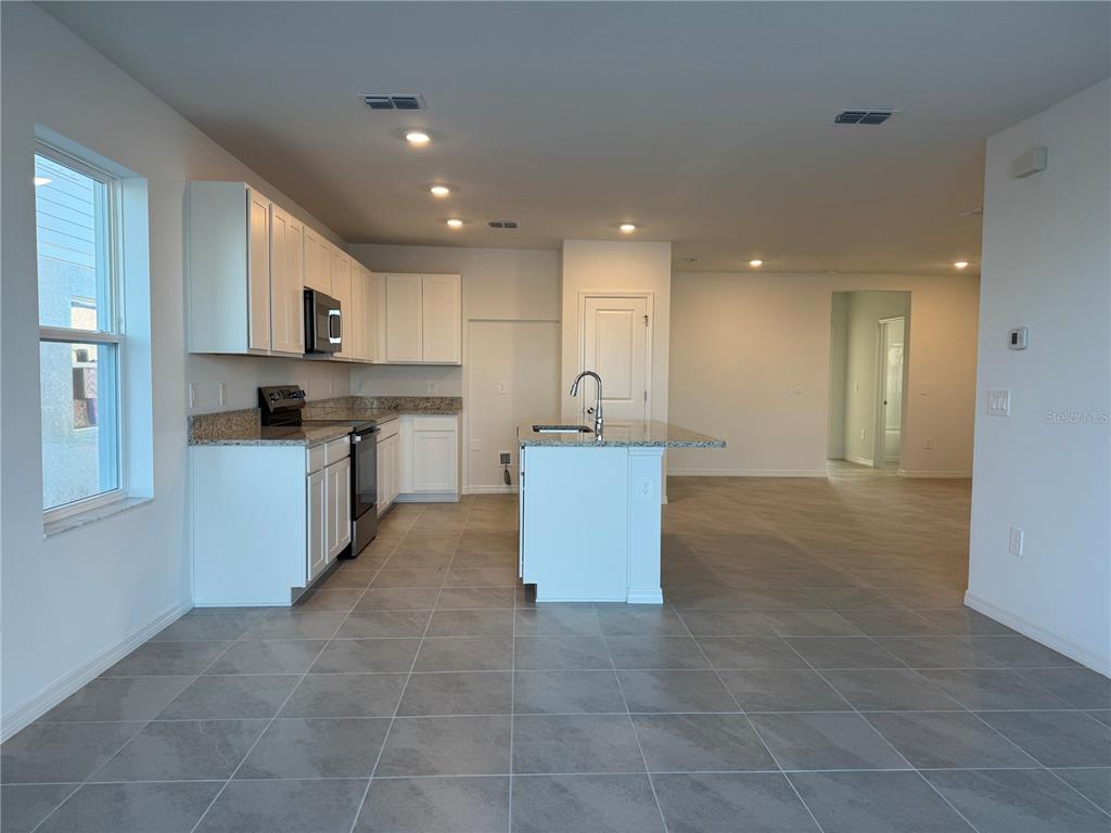 9026 Optimist Way Palmetto, FL 34221 - Photo 3 of 21 a large kitchen with stainless steel appliances granite countertop a large counter top and a stove