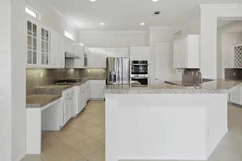 a kitchen with granite countertop a stove microwave and refrigerator