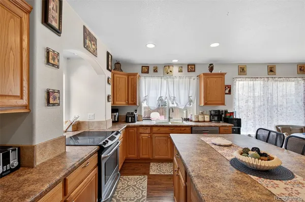 a kitchen with granite countertop a sink stove and cabinets