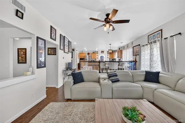 a living room with furniture and a view of kitchen