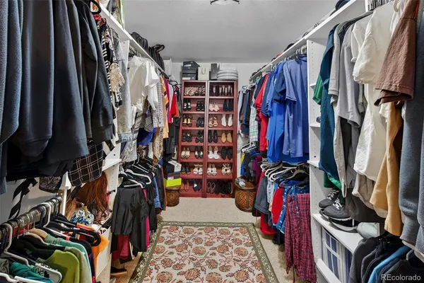 a view of walk in closet with clothes