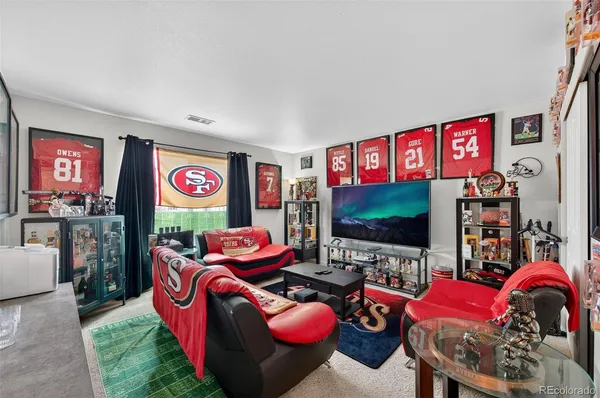 a living room with furniture a flat screen tv and a floor to ceiling window