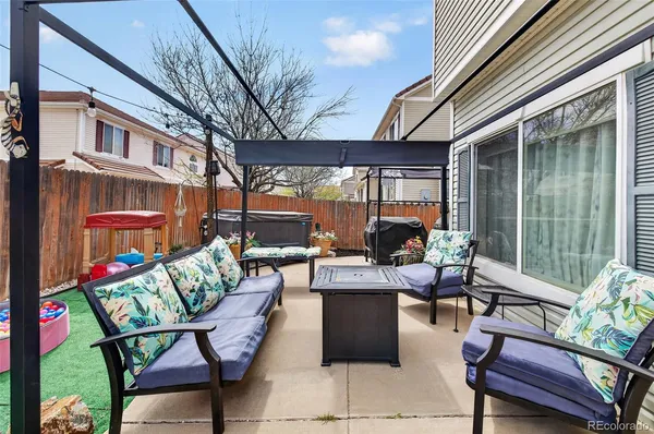 a view of a patio with couches table and chairs and potted plants