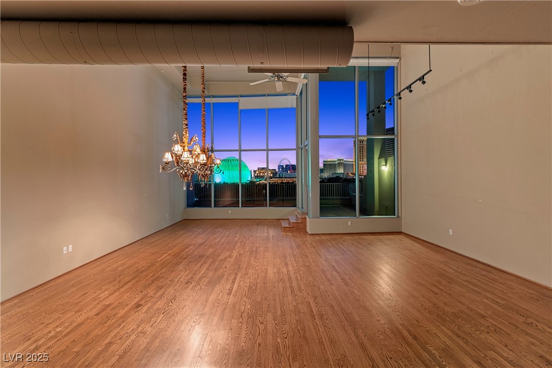 360 East Desert Inn Road, Unit 605 Las Vegas, NV 89109 - Photo 11 of 43 Spare room with ceiling fan, wood finished floors, a chandelier, and a city view
