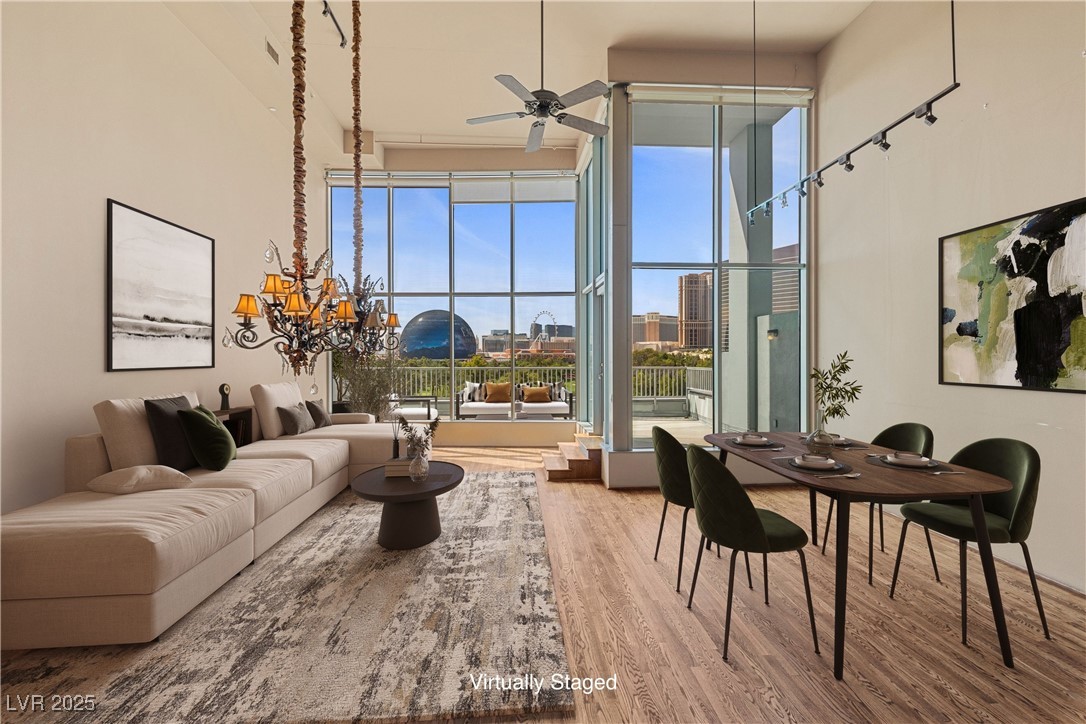360 East Desert Inn Road, Unit 605 Las Vegas, NV 89109 - Photo 2 of 43 Virtually staged |Living room featuring light wood-type flooring, a high ceiling, ceiling fan, and a city view