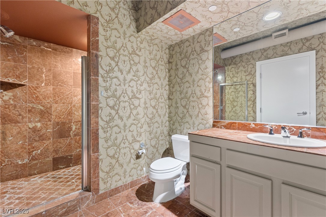 360 East Desert Inn Road, Unit 605 Las Vegas, NV 89109 - Photo 24 of 43 Full bath featuring wallpapered walls, a stall shower, vanity, and dark tile patterned flooring