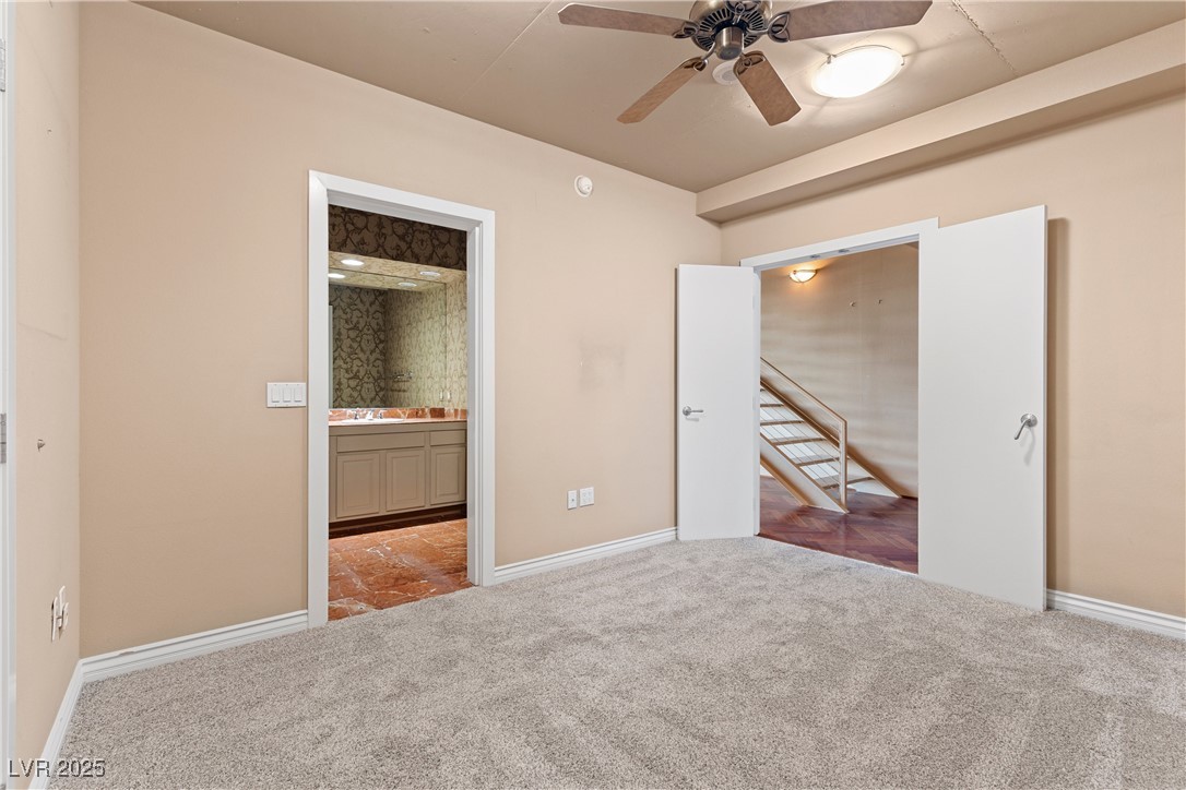 360 East Desert Inn Road, Unit 605 Las Vegas, NV 89109 - Photo 25 of 43 Downstairs bedroom featuring carpet floors, a ceiling fan, and ensuite bath