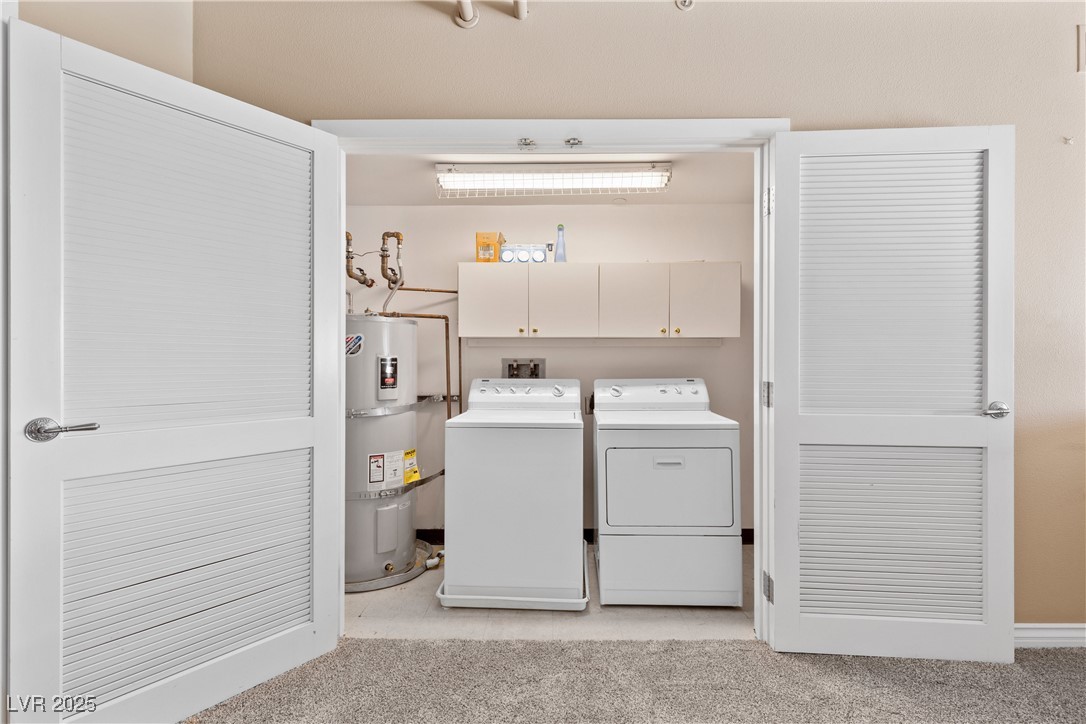 360 East Desert Inn Road, Unit 605 Las Vegas, NV 89109 - Photo 28 of 43 Laundry room featuring light carpet, strapped water heater, washer and dryer, and cabinet space
