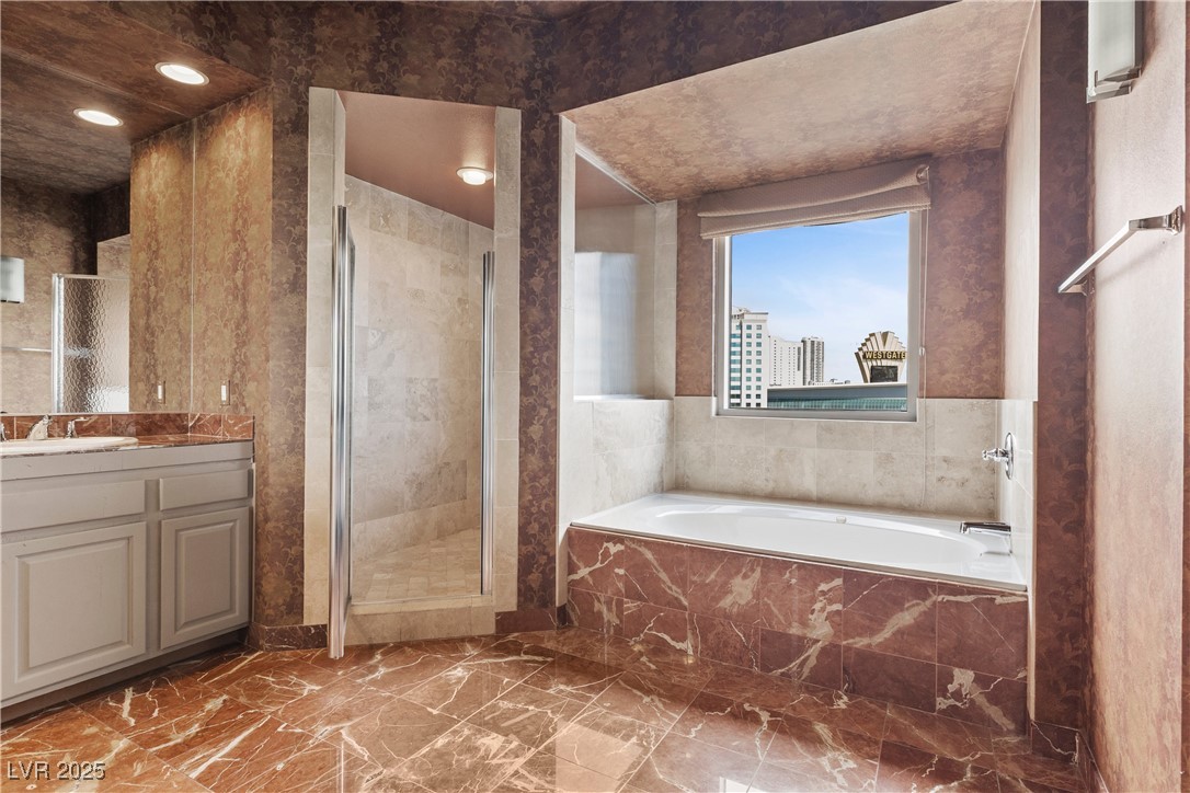 360 East Desert Inn Road, Unit 605 Las Vegas, NV 89109 - Photo 33 of 43 Bathroom with a garden tub, a shower stall, vanity, and marble look tiles