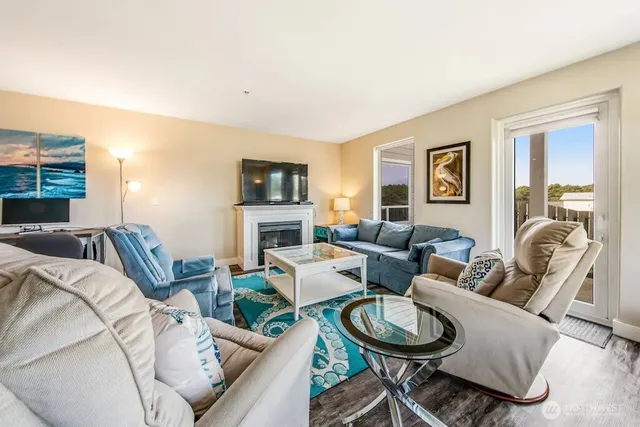 a living room with furniture a fireplace and a flat screen tv