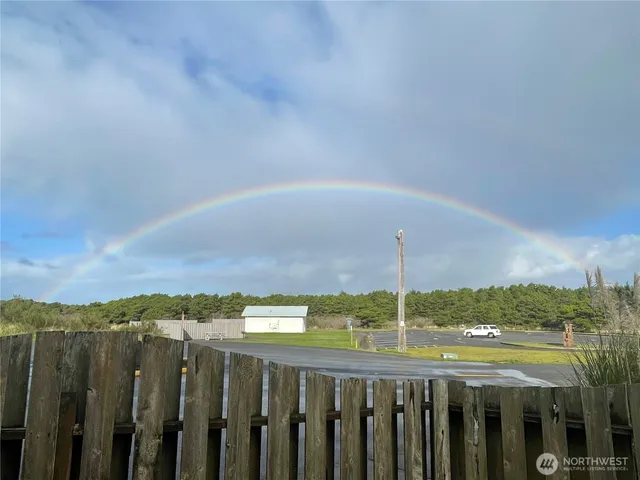 a view of a big house with a big yard and large trees