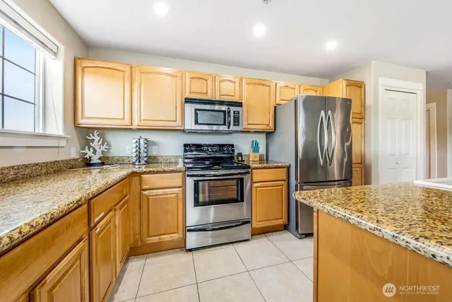 a kitchen with stainless steel appliances granite countertop a stove a sink and a refrigerator