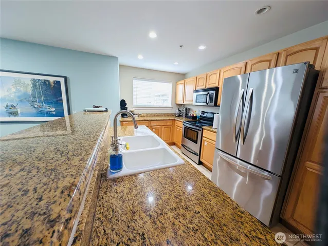 a kitchen with stainless steel appliances granite countertop a refrigerator and a sink