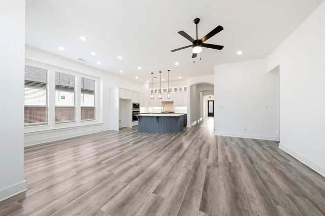 a view of a kitchen with wooden floor and a ceiling fan