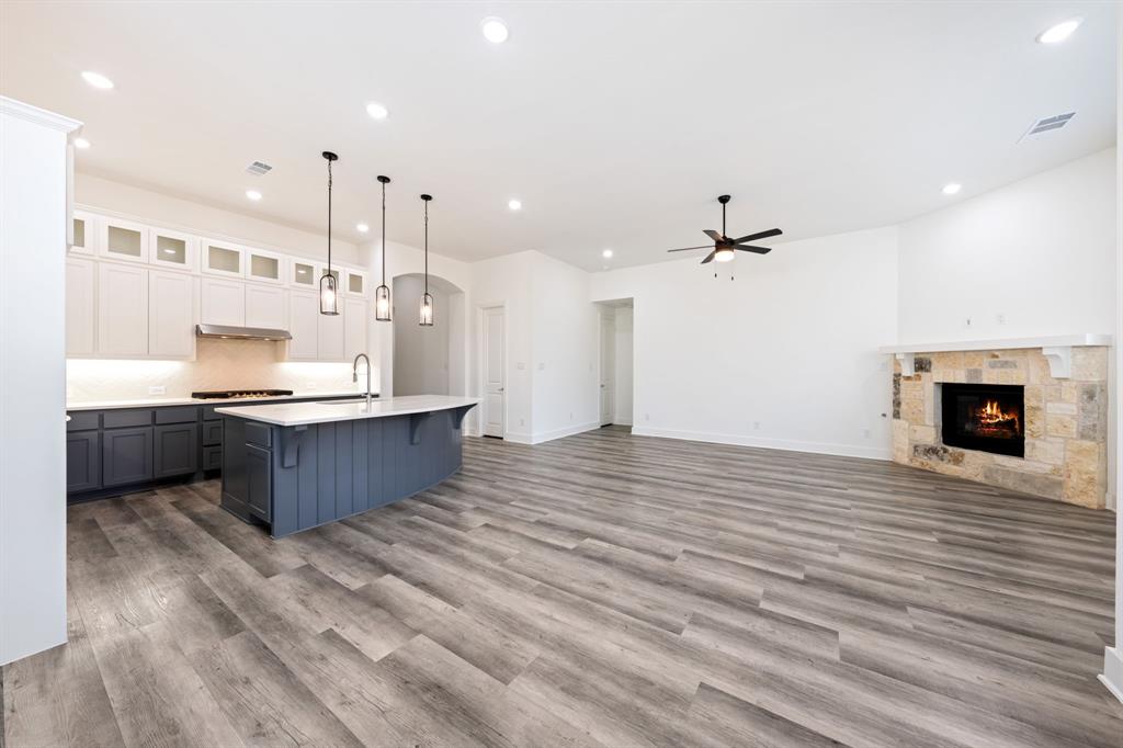 1606 Bulls Eye Road Mansfield, TX 76063 - Photo 7 of 27 a large white kitchen with a large kitchen island a sink stainless steel appliances and cabinets