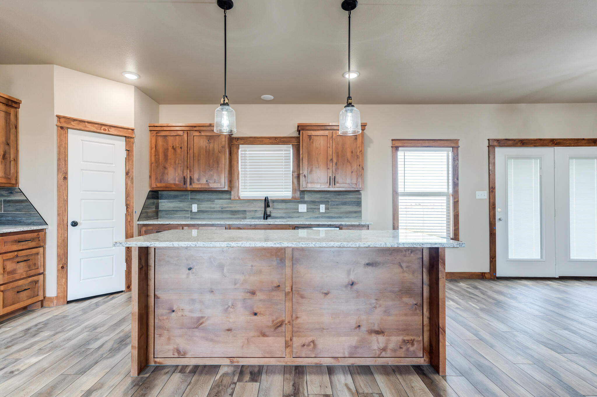 12401 North C R 2900 Lubbock, TX 79403 - Photo 13 of 40 a kitchen with kitchen island granite countertop a stove a sink and white cabinets with wooden floor
