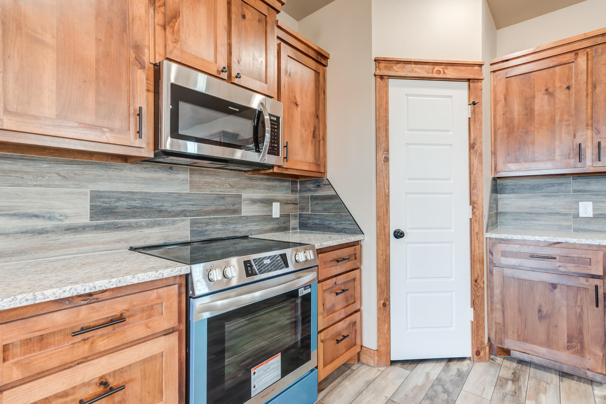 12401 North C R 2900 Lubbock, TX 79403 - Photo 15 of 40 a kitchen with granite countertop cabinets stainless steel appliances and wooden floor