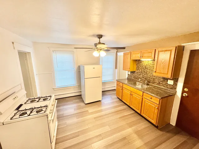 a view of a kitchen with wooden floor and electronic appliances