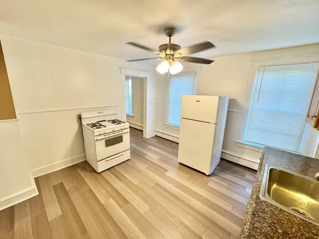 a view of a refrigerator in kitchen and wooden floor